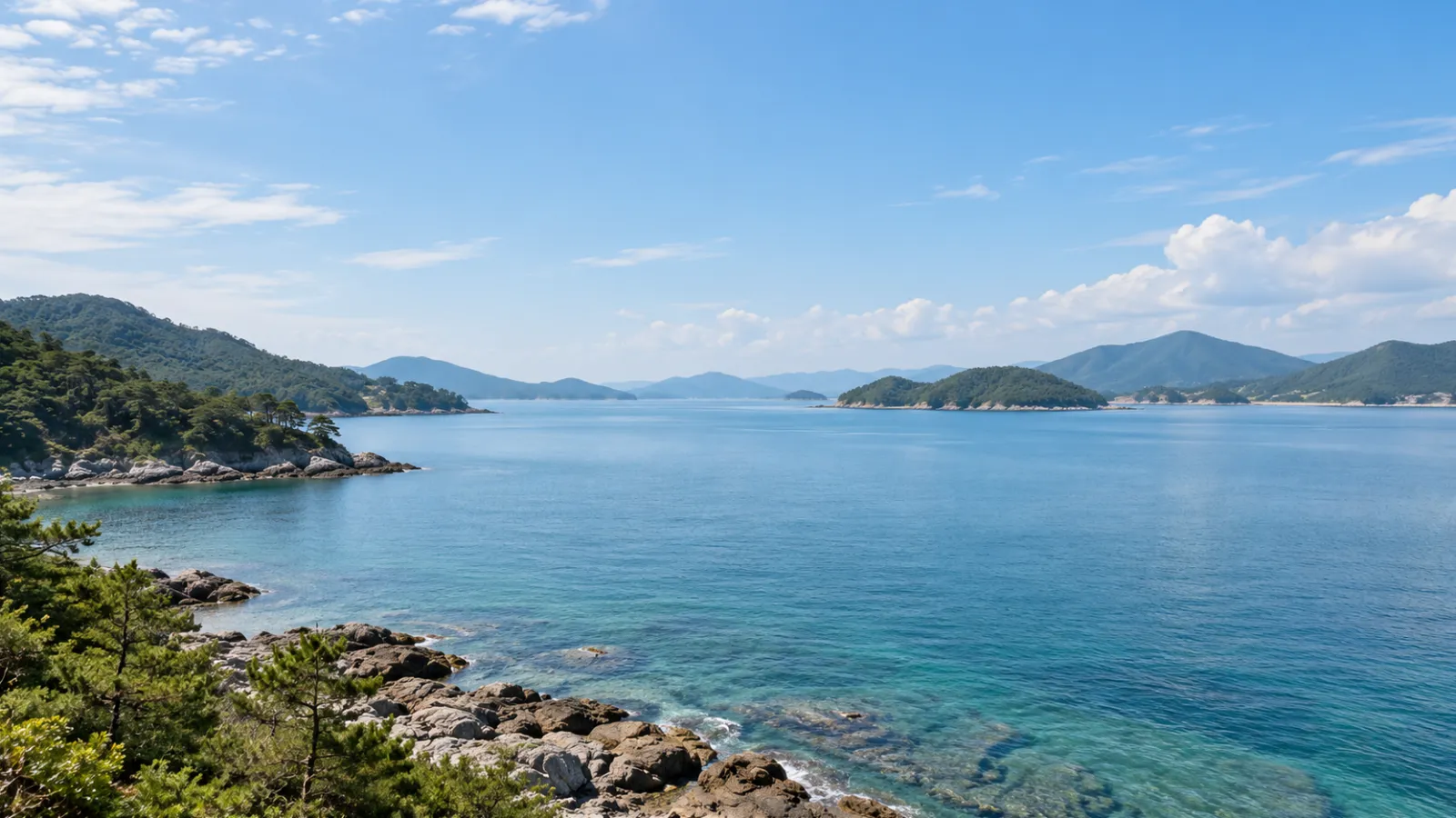 경상남도 고성군의 남해안 만과 주변 산지 지형을 참고해 만든 AI 분위기 이미지입니다. 잔잔한 바다와 숲이 우거진 해안의 가상 장면이며 실제 지역이나 학교·학원 건물을 촬영한 사진이 아닙니다.