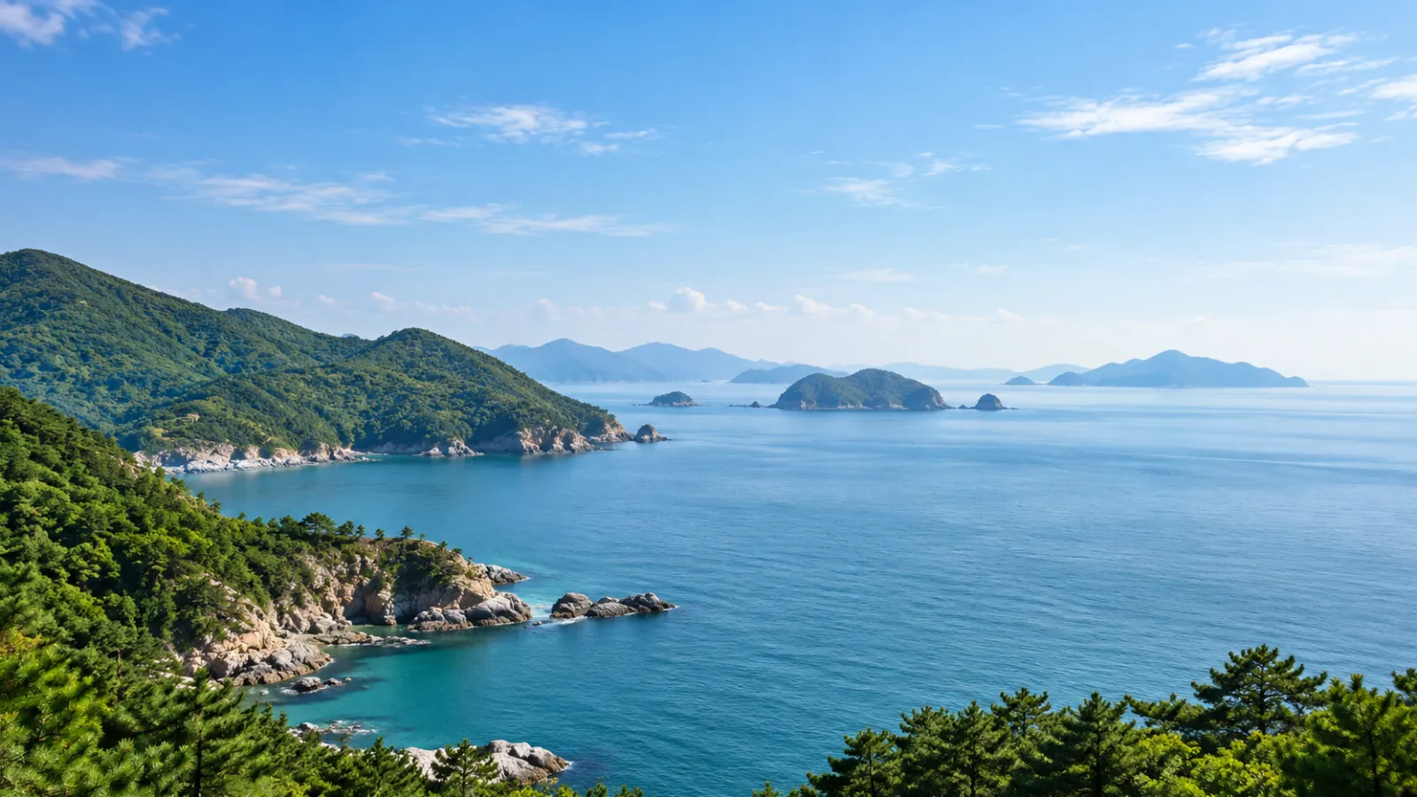 경상남도 남해군의 바다·섬·산 지리 특성을 참고해 AI로 생성한 가상 지역 분위기 이미지입니다. 푸른 바다와 녹음이 우거진 해안, 먼 섬들이 보이며 실제 장소나 학교·학원 건물을 촬영한 사진이 아닙니다.